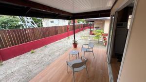 a patio with two chairs and a table and a fence at Hiti Village G2 in Tikehau Airport