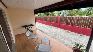 a screened in porch with two chairs and a piano at Hiti Village G2 in Tikehau Airport +2 photos
