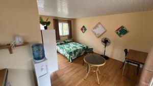 a bedroom with a bed and a table in a room at Hiti Village G2 in Tikehau Airport