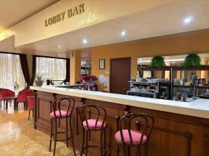 a lobby with a bar with pink chairs at Hotel OTDIH in Kavarna
