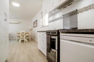a kitchen with white cabinets and a stove top oven at Bayview Motel in Esperance