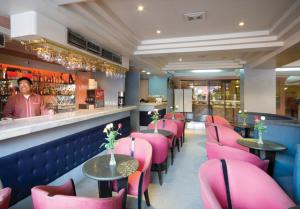 a restaurant with pink chairs and a man standing behind the counter at Grand City Hotel Inc. in Cagayan de Oro +25 photos