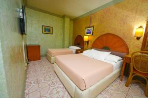 a hotel room with a bed and a television at Grand City Hotel Inc. in Cagayan de Oro