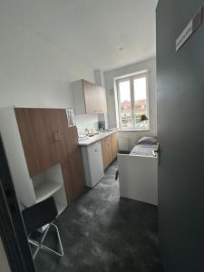 a small kitchen with a sink and a window at Petite chambre in Halluin