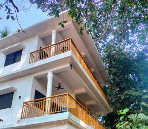 a house with a balcony on the side of it at Tree hugs mandrem in Mandrem