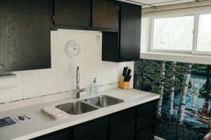 a kitchen with a sink and a clock on the wall at Outbounder in Bayfield