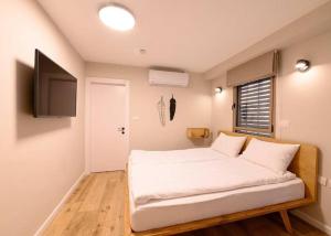 a bedroom with a bed and a television in it at אחוזת נופש ביער -ווילה עם בריכת ספא וזרמי עיסוי in Ma'alot Tarshiha +12 photos
