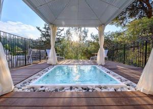 a swimming pool on a deck with a gazebo at אחוזת נופש ביער -ווילה עם בריכת ספא וזרמי עיסוי in Ma'alot Tarshiha