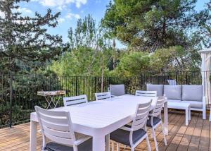 a white table and chairs on a deck at אחוזת נופש ביער -ווילה עם בריכת ספא וזרמי עיסוי in Ma'alot Tarshiha