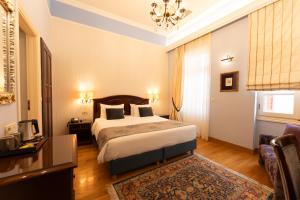 a hotel room with a bed and a couch at Aetoma Hotel in Nafplio