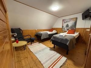 a room with two beds and a chair in it at Arctic Lodge Hetan Kota in Enontekiö