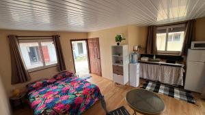 a bedroom with a bed and a table and a refrigerator at Hiti Village G3 in Tikehau