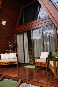 a screened in porch with two chairs and windows at Sol y Luna Chalet with volcano view and Jacuzzi in Fortuna