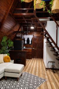 a living room with a staircase and a couch at Sol y Luna Chalet with volcano view and Jacuzzi in Fortuna +16 photos