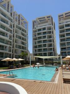 a swimming pool with two tall apartment buildings at Amor Club Luxury Suite in Eilat