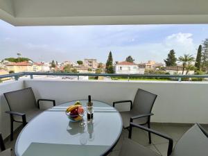a white table with a bowl of fruit on a balcony at STAY Sun Line Apartment in Nicosia