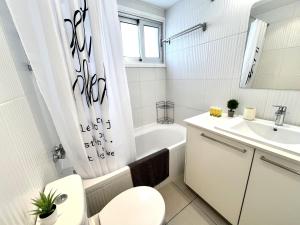 a white bathroom with a toilet and a sink at STAY Sun Line Apartment in Nicosia +15 photos
