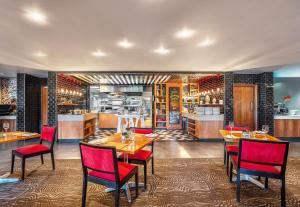 a restaurant with tables and chairs and a kitchen at SunSquare Cape Town Gardens in Cape Town