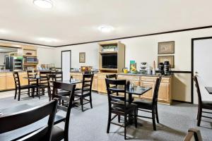 a dining room with tables and chairs and a kitchen at Quality Inn Mount Vernon in Mount Vernon