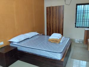 a bed in a room with a wooden bed frame at Le DPS Viste in Rāyampālaiyam