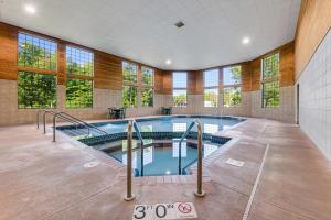 a large indoor swimming pool in a building with windows at Comfort Inn & Suites Weston - Wausau in Weston