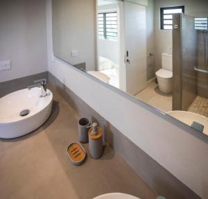 a bathroom with two toilets and a sink and a mirror at Salty Sands Studio in Rivière Noire +28 photos