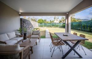a patio with a table and chairs and a couch at Salty Sands Studio in Rivière Noire