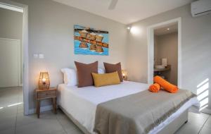 a bedroom with a bed with orange pillows on it at Salty Sands Studio in Rivière Noire