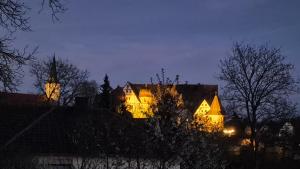 a lit up building with a clock tower at night at CasaFranken in Wiesenthau