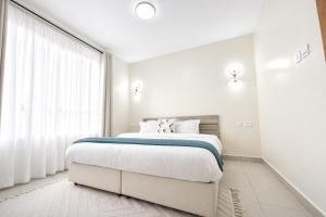 a bedroom with a large bed and a large window at Shawmut Executive Suites With Heated Pool, GYM, Secure Parking, Full Power Backup in Nakuru +11 photos