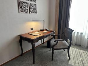 a desk in a room with a chair and a telephone at Jubilee Prestige Hotel Ratchadapisek in Bangkok