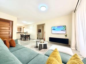 a living room with a couch and a table at Shawmut Executive Suites With Heated Pool, GYM, Secure Parking, Full Power Backup in Nakuru
