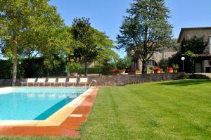 a swimming pool in a yard next to a house at Podere Lornanino in Monteriggioni