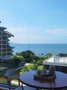 a table on a balcony with a view of the ocean at Man Man hotel in Wutongkeng