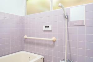 a bathroom with purple tiles and a tub and a mirror at Yokosuka Guest House in Yokosuka +35 photos