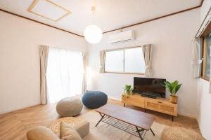 a living room with a tv and a table at Yokosuka Guest House in Yokosuka