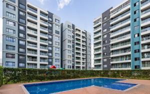 an apartment complex with a swimming pool in front of two tall buildings at Jkia Airport 24 Hours Transit studio next 67hotel in Nairobi