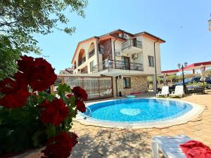 a villa with a swimming pool in front of a house at Апартхотел Созополски перли in Sozopol