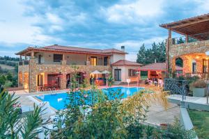 a house with a swimming pool in front of it at Serenity Residence in Neoi Epivates