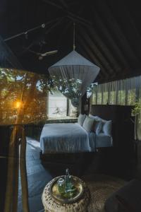 a bedroom with a bed and a table and a chandelier at Oshom Bali at Nuanu Creative City in Canggu +45 photos