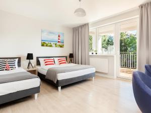 a bedroom with two beds and a window at Villa Milla in Łeba