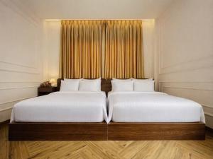 a bedroom with two beds and a window at Vũ Ngọc Hotel Núi Sam in Chau Doc