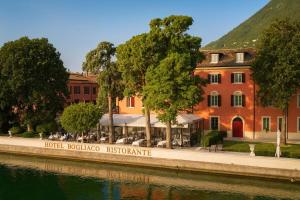 a building next to a river in front of a building at Boutique Hotel Bogliaco in Gargnano