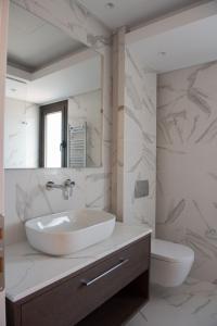 a white bathroom with a sink and a toilet at Serenity Residence in Neoi Epivates +24 photos