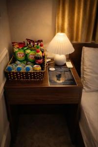 a table in a hotel room with a lamp and drinks on it at Vũ Ngọc Hotel Núi Sam in Chau Doc