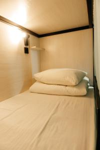 a bed with two pillows on it in a room at Азия Hostel in Shymkent