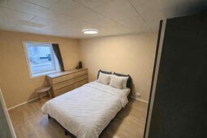 a small bedroom with a bed and a window at Hel hus i rolig by in Birkelse