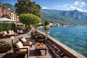 a restaurant with a view of the water and mountains at Boutique Hotel Bogliaco in Gargnano