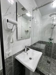 a bathroom with a sink and a shower with a mirror at Азия Hostel in Shymkent +30 photos
