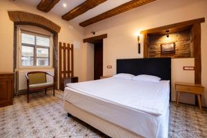 a bedroom with a large white bed and a chair at Casa Wagner in Braşov